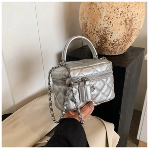 Detailed macro of silver quilted mini box bag with rose zipper charms and metal chain