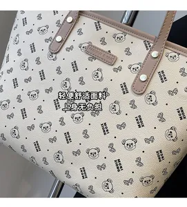 Dettaglio della borsa tote con stampe di orsetti e manici marroni rinforzati in pelle
