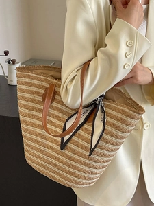 Fashionable large woven straw tote bag with leather straps and decorative silk scarf