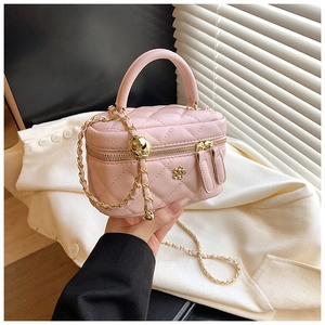 Detail of pink quilted leather handbag with gold flower clasp and chain strap