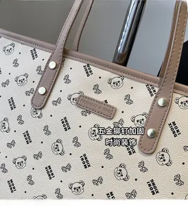 Dettaglio della borsa tote in pelle beige con stampe di orsetti e rivetti d'argento