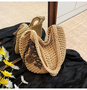 Détail du sac à main tissé en forme de cœur avec breloque bonny et fleurs