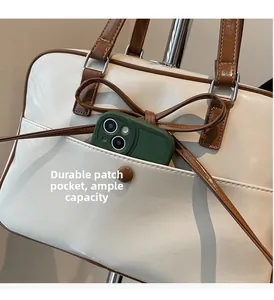 Close-up of front pocket with magnetic clasp on a white retro leather handbag