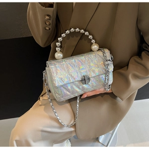 Detail of silver holographic quilted handbag with metallic beads and pearl handle