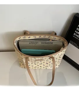 Vista macro dell'interno della borsa tote beige con spazio per laptop e libri