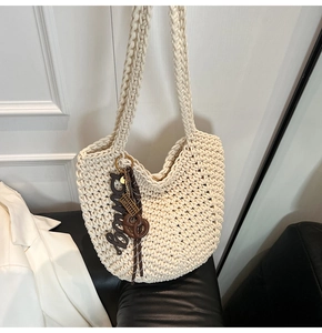 Détail du sac fourre-tout en maille écrue avec pendentif Enjoy et nœud décoratif