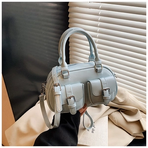 Detail view of light blue bowling bag featuring dual front pockets and silver buckles