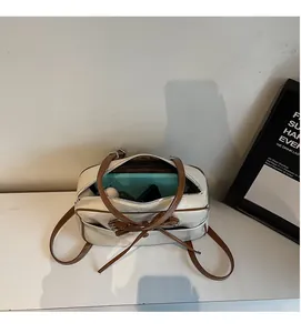 Top view of cream tote bag showing spacious interior with brown leather trim and bow detail