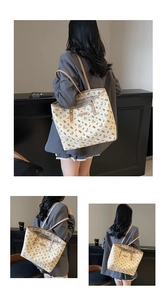 Dettaglio della grande borsa tote crema con stampe di orsi neri e manici in pelle marrone
