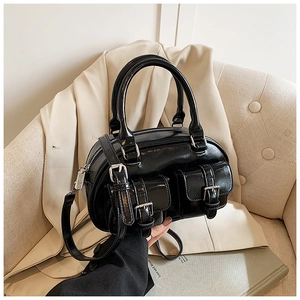 Close-up of black glossy patent leather bowling bag with twin front buckle pockets