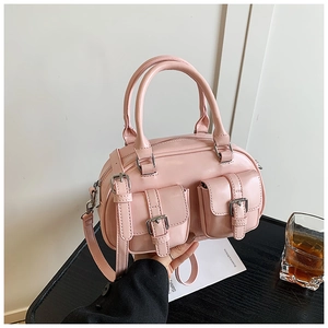 Detail of pink glossy leather bowling bag with silver buckles and double front pockets