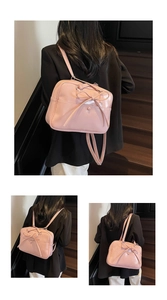Detail of pink patent leather tote with bow and button accent on black staircase