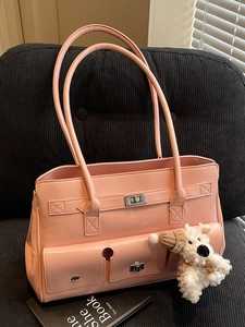 Pink faux leather shoulder bag with metallic locks and a cute plush dog charm