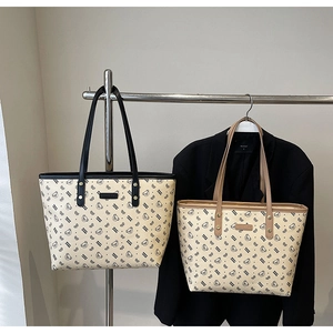 Dettaglio della borsa tote in tela con stampa orso cartoon e patch logo in pelle rettangolare