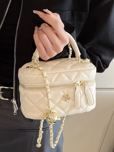 Elegant cream quilted vanity bag with golden camellia logo and chain shoulder strap