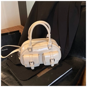 Detail showing creamy white glossy bowling bag with silver zippers and buckle pockets
