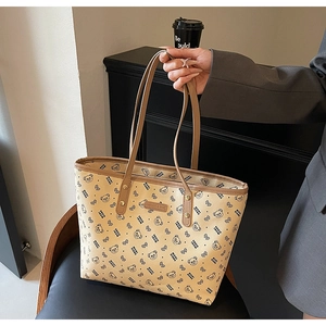 Dettaglio borsa shopper beige con stampa di orsetto e manici in pelle marrone