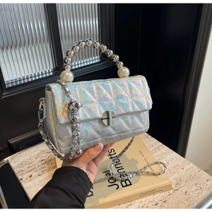 Detail of silver holographic quilted handbag with pearl accents and metal bead handle