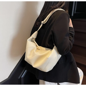 Detail of soft cream white hobo bag showing litchi grain texture and knotted strap detail