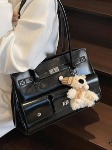 Chic black vintage leather underarm bag with silver buckles and a cute bear charm