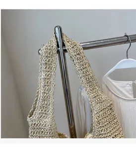Detail of the woven straw tote bag handles showing durable handmade crochet texture