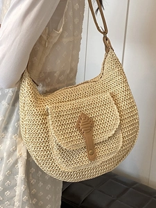 Beige woven straw shoulder bag in hobo crescent style with brown leather strap detail