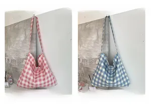 Detail view of pink and blue gingham canvas tote bags with wide straps and side tags