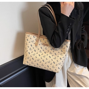Dettaglio della borsa tote stampata con manici in pelle marrone e motivi di orsi