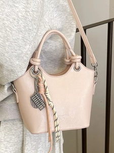 Borsa a secchiello rosa nudo alla moda con manico a nodi e ciondolo a pallottoliere in metallo