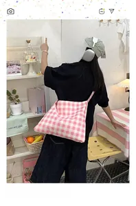 Lifestyle view of large pink gingham canvas tote bag worn by model in a cozy room