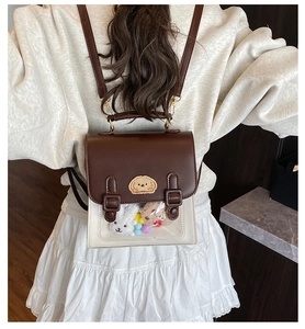 Close-up of vintage British school style backpack with clear PVC window and plush toys