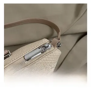 Detail of woven fabric handbag featuring premium leather trim and smooth silver zipper hardware