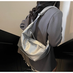 Detail of silver metallic hobo bag featuring a knotted wide strap and textured finish
