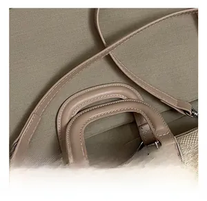 Detail of minimalist woven handbag with khaki leather handle and silver metal hardware