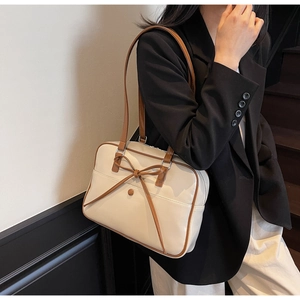 Detail of vintage oil wax leather underarm bag featuring a classic bow and long handle