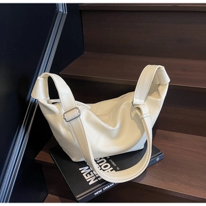 Detail of soft cream leather tote bag with lychee texture on wooden stairs
