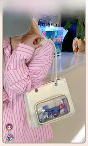 Detail view of a white faux leather ita bag with a clear PVC window for pin display