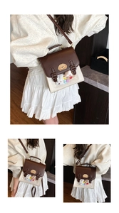 Detail view of the transparent PVC window with plush charms on the vintage satchel