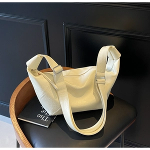 Close-up of cream white crescent tote bag with stitched leather and silver metal buckle