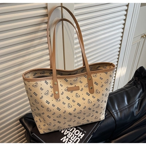 Dettaglio della borsa tote in pelle PU beige con motivi di orsi e manici marroni