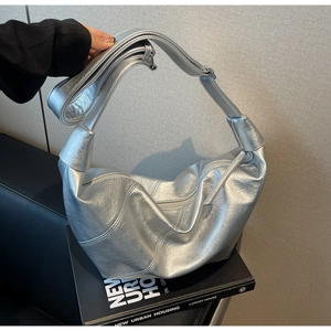 Detail of silver metallic hobo bag featuring a unique knotted shoulder strap and zipper closure