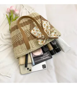 Detail of spacious woven straw tote interior with smartphone and makeup essentials