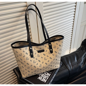 Dettaglio dei motivi a orsetto e bordi neri sulla borsa tote color beige