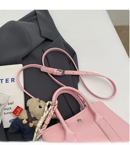 Sac seau rose en cuir grainé avec finitions argentées et charmant petit ours en peluche