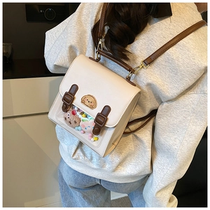 Close-up of beige British style backpack with puppy embroidery and clear window detail