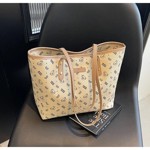 Dettaglio della grande borsa tote con stampe di orsi e etichetta in pelle su sedia nera