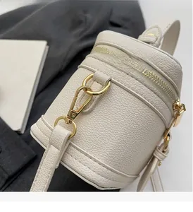 Close-up of litchi grain cream box bag with pale gold zippers and leather texture