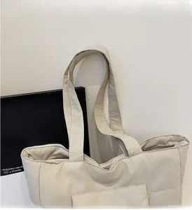 Détail du grand sac cabas beige avec des bretelles larges et des poches latérales
