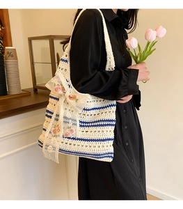 Detail of hand-woven tote bag with cream cotton texture and blue striped pattern decoration