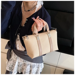 Detail of minimalist beige woven handbag with synthetic leather trim and silver zipper